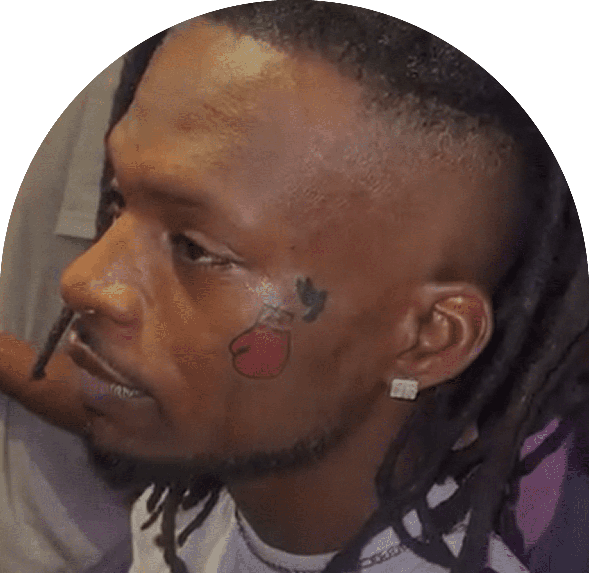 Man with dreadlocks and face tattoo profile.