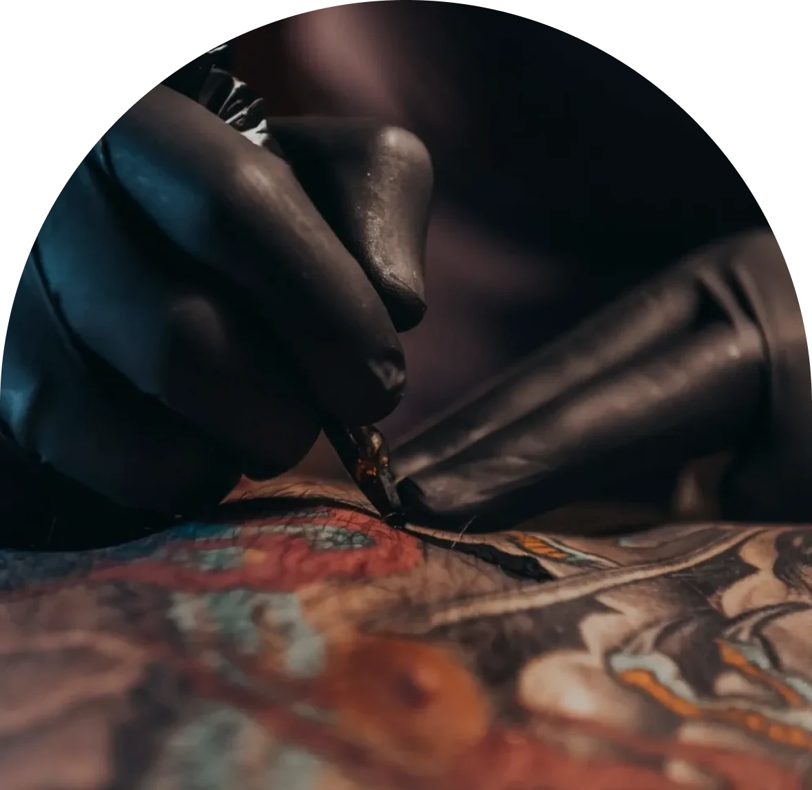 Tattoo artist working on colorful design.